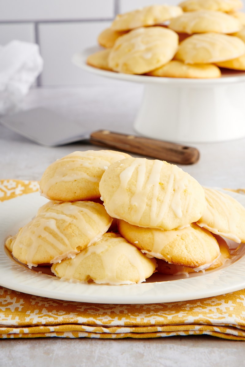 Pineapple Cream Cheese Cookies piled on a white plate with more cookies in the background