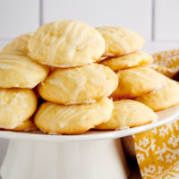 Pineapple Cream Cheese Cookies piled on a small white cake stand