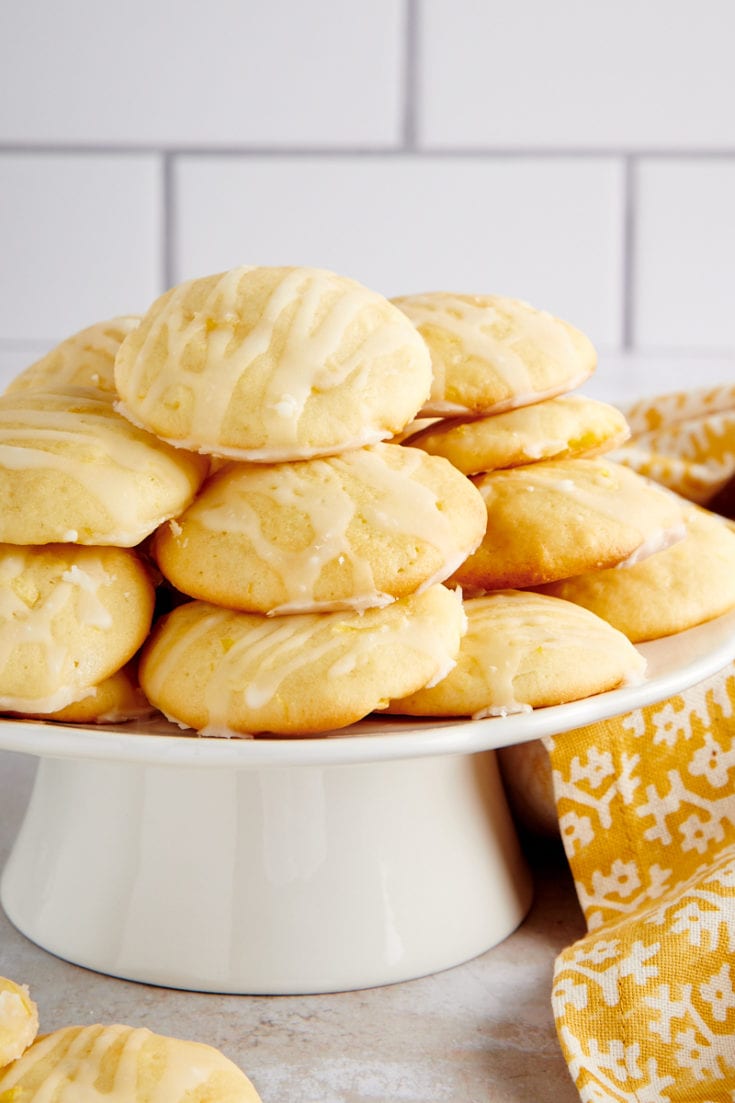 Pineapple Cream Cheese Cookies piled on a small white cake stand