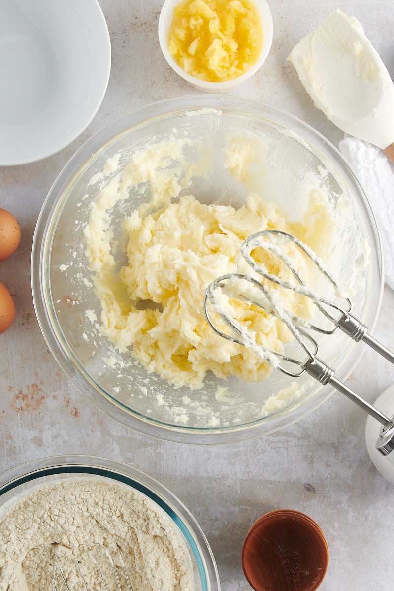 overhead view of butter, cream cheese, and sugar mixed in a glass mixing bowl