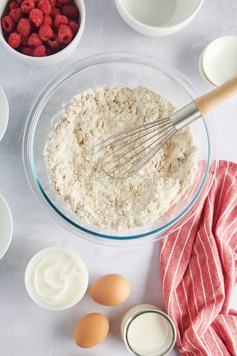 Overhead view of dry muffin ingredients in bowl with whisk