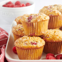 Raspberry oat muffins stacked on tray