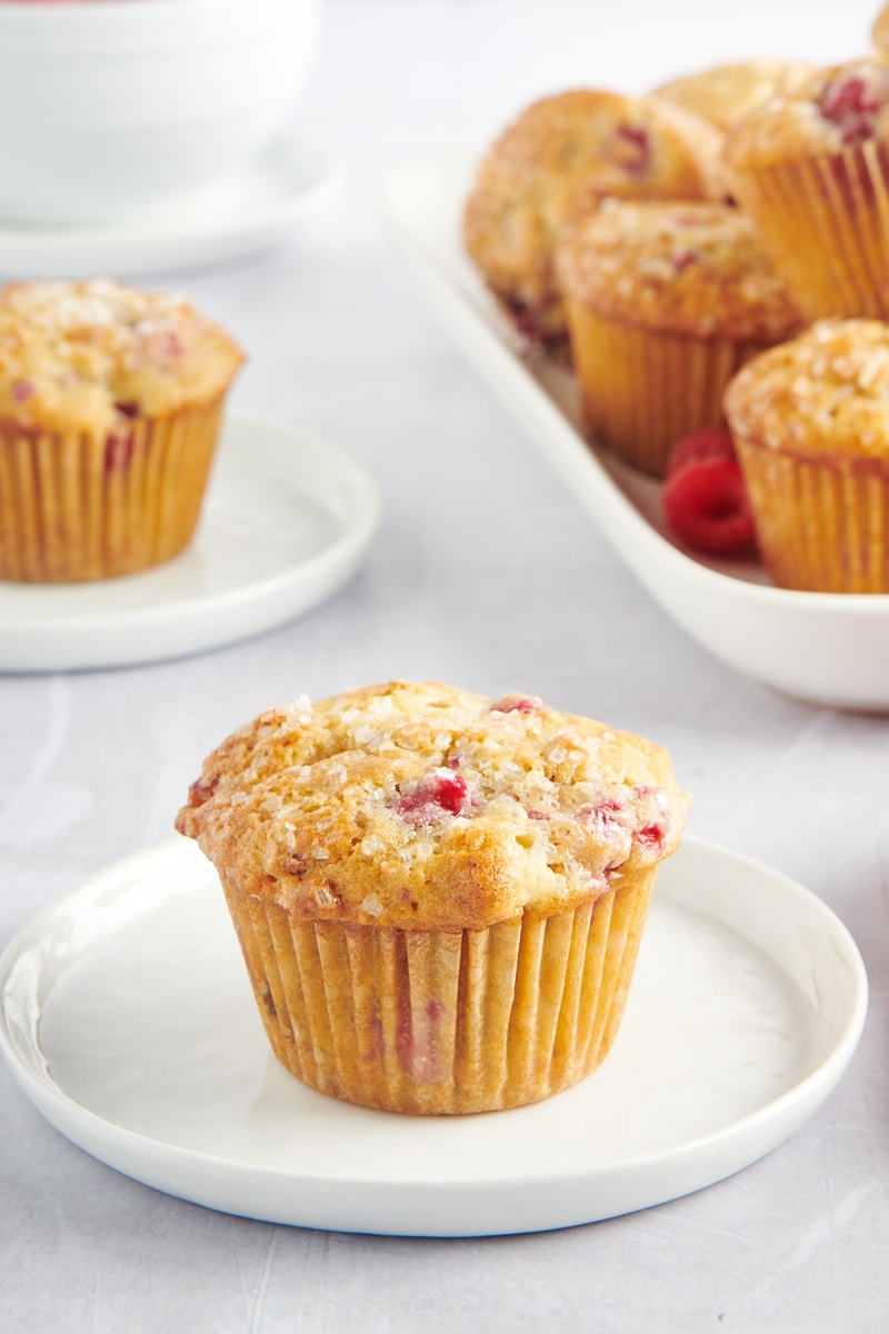 Raspberry oat muffin on a plate with muffins in background