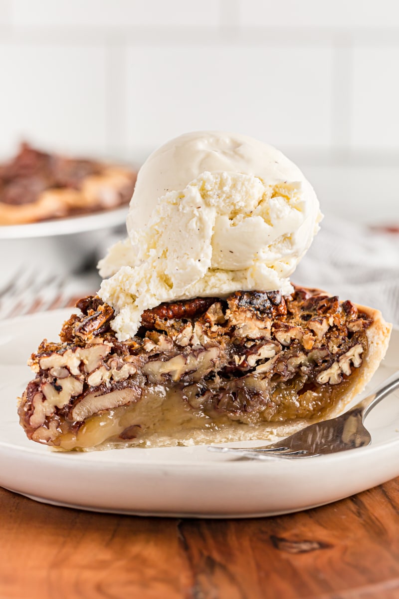 Slice of pecan pie on plate with ice cream