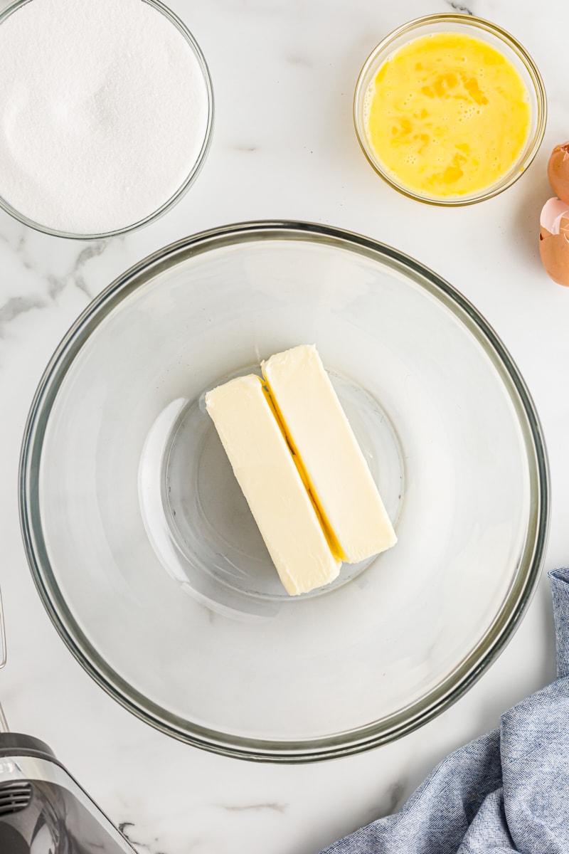 Two butter sticks in glass mixing bowl