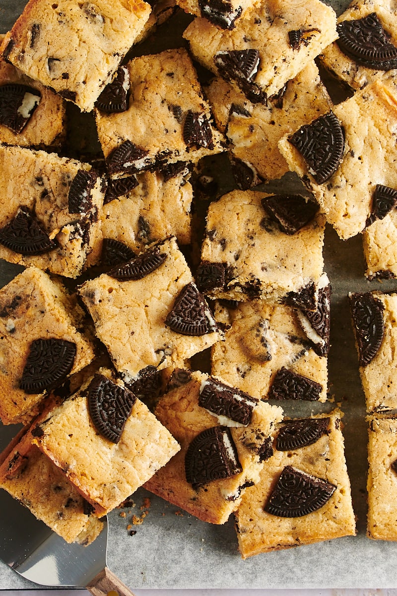 overhead view of sliced Cookies and Cream Blondies piled on parchment paper