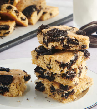 stack of Cookies and Cream Blondies on a black-rimmed white plate