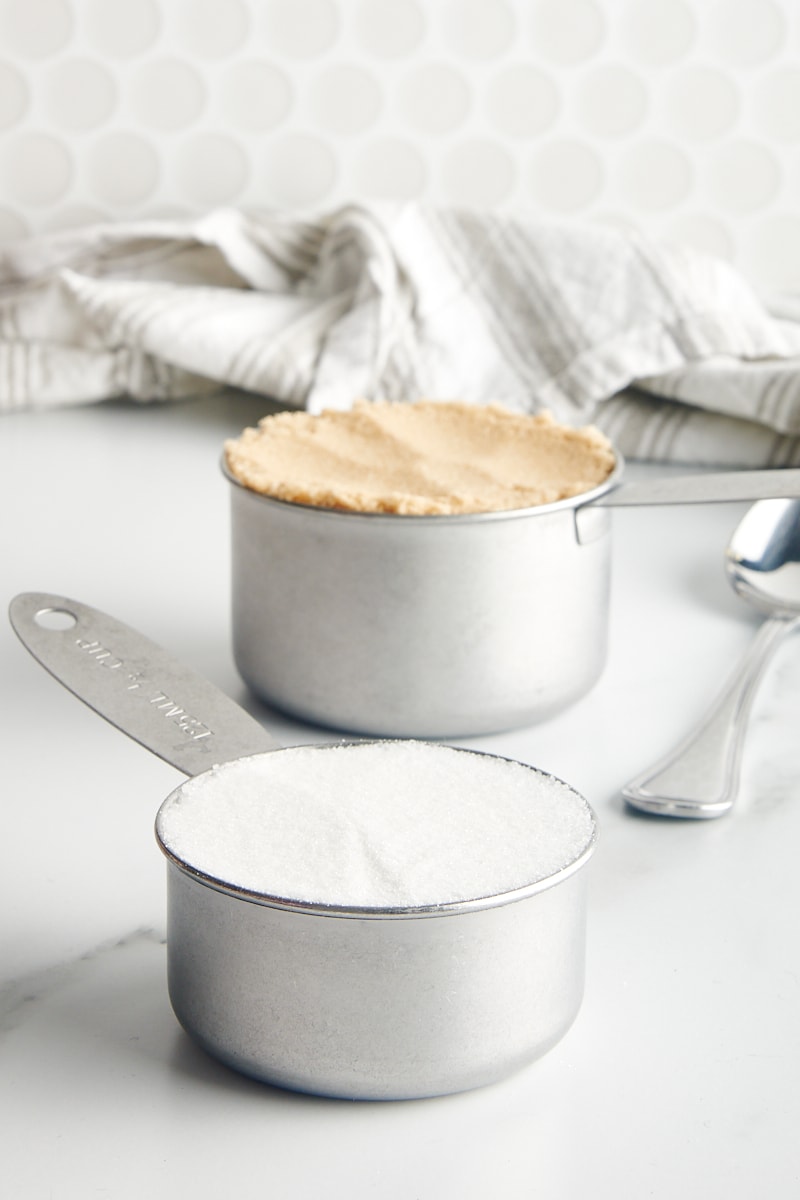 granulated sugar and brown sugar in metal measuring cups