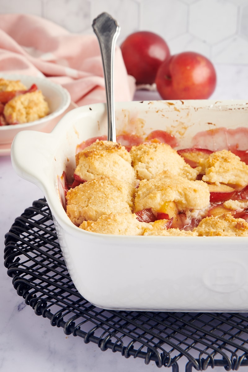 Plum Cobbler in a baking dish on a wire rack