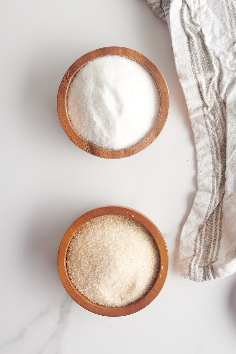 overhead view of granulated sugar and cane sugar in small wooden bowls