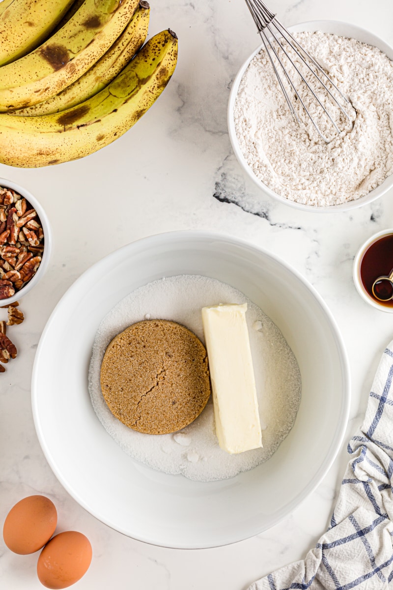 Overhead view of butter and sugars in mixing bowl