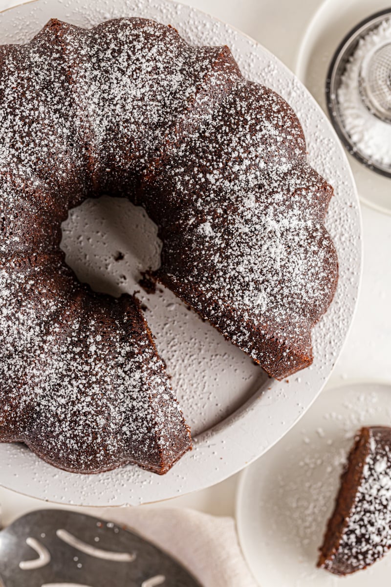 Overhead view of chocolate amaretto bundt cake on cake stand with slice removed