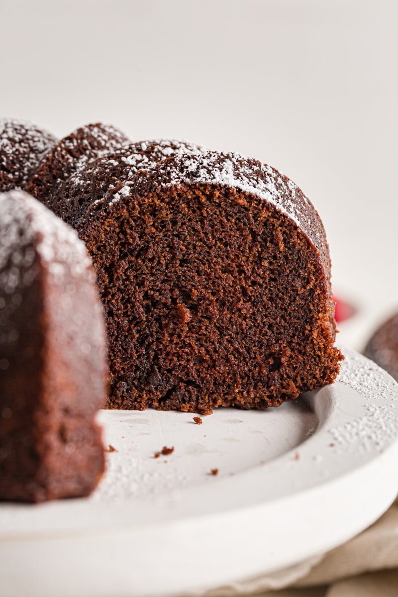 Chocolate amaretto bundt cake on cake stand with pieces removed