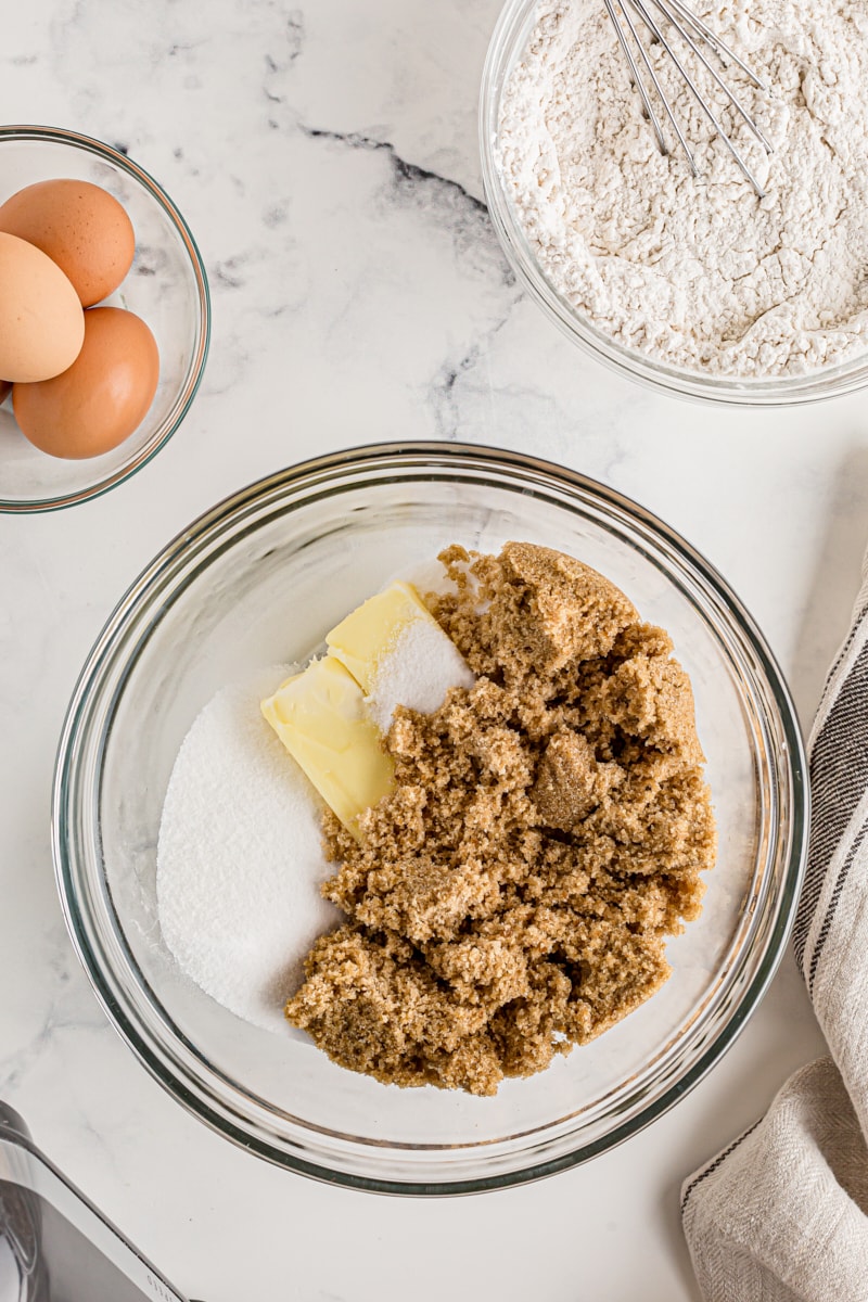 Overhead view of butter and sugars in mixing bowl