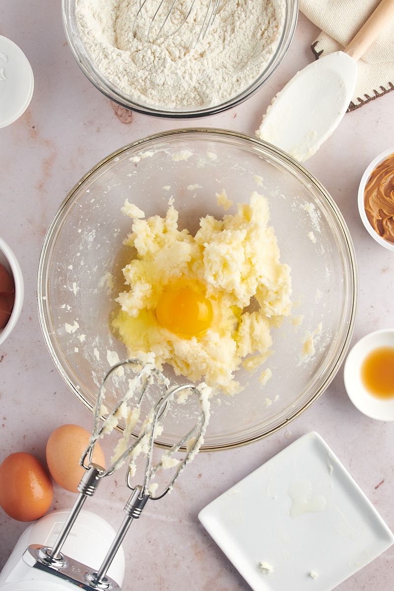 Overhead view of egg added to creamed butter and sugar