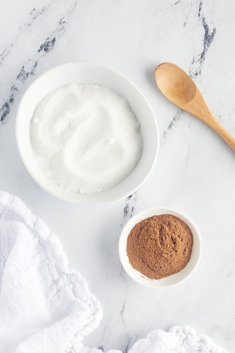 overhead view of sugar and cinnamon in white bowls