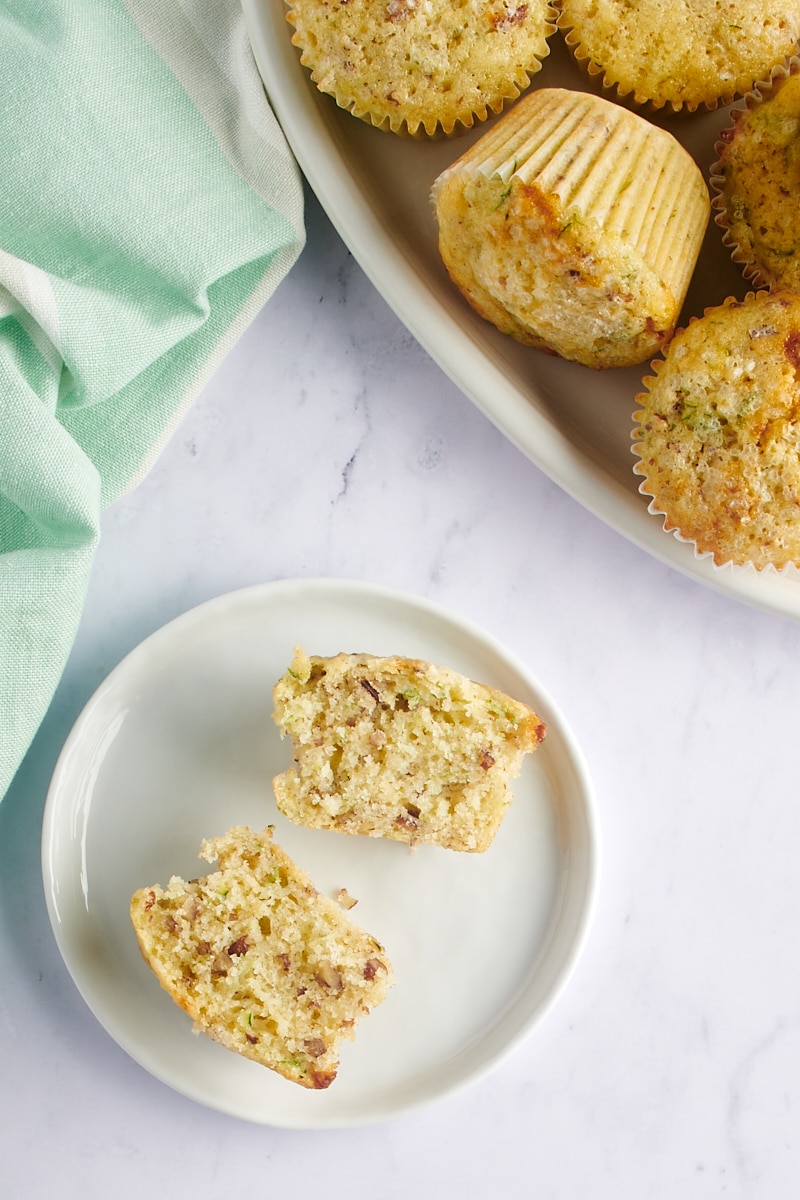 overhead view of a Lemon Zucchini Muffin split in half on a white plate