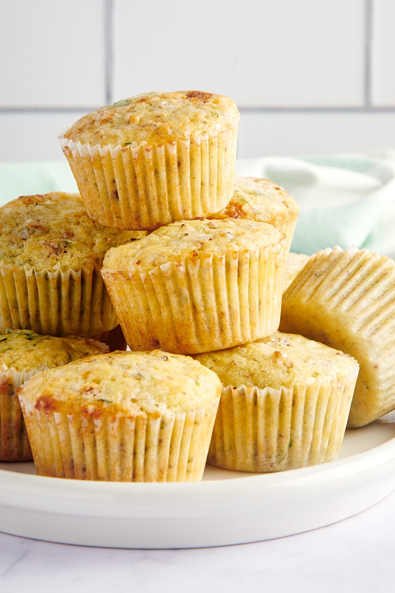 Lemon Zucchini Muffins stacked on a white plate