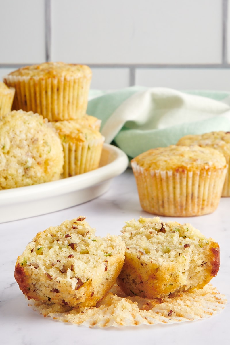 a Lemon Zucchini Muffin split in half with more muffins in the background