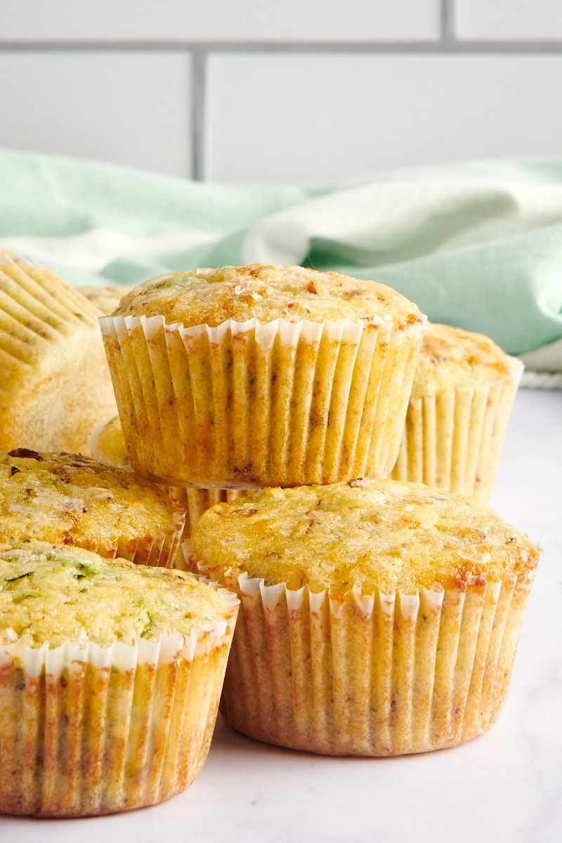 stacks of Lemon Zucchini Muffins on a marble countertop