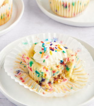 an unwrapped Mini Funfetti Cheesecake with a bite missing