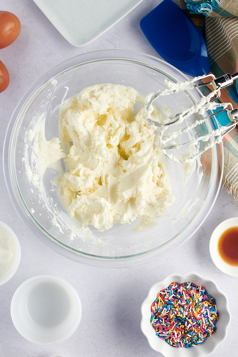 overhead view of mixed cream cheese and sugar in a mixing bowl