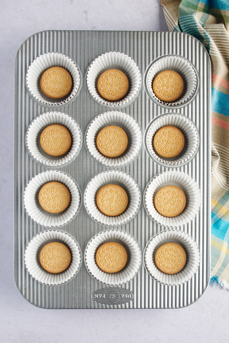 visão aérea de Golden Oreos em forros de papel em uma panela de muffin