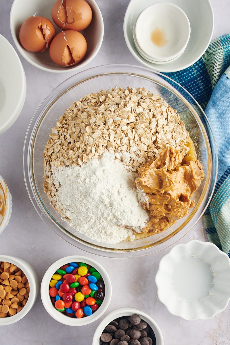 Flour, oats, and peanut butter in a bowl of monster cookie dough.