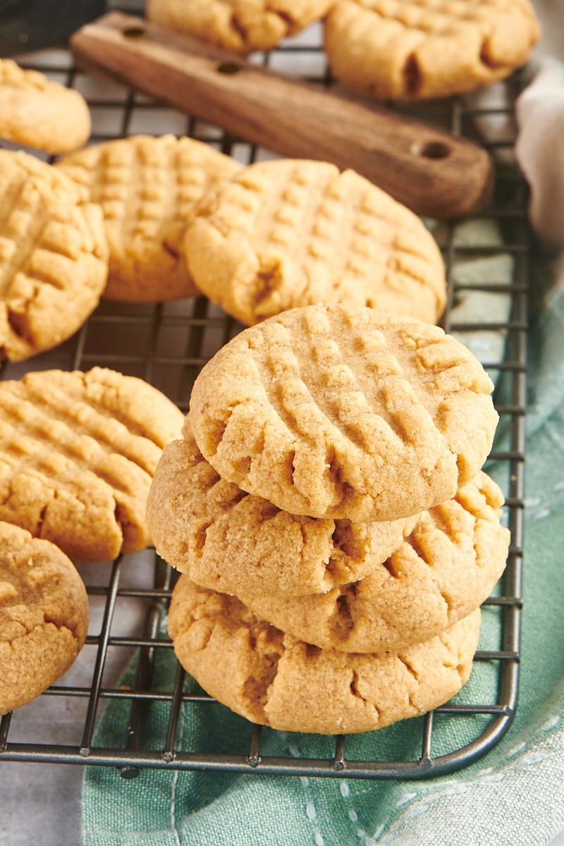 3-Ingredient Peanut Butter Cookies stacked and scattered on a wire rack