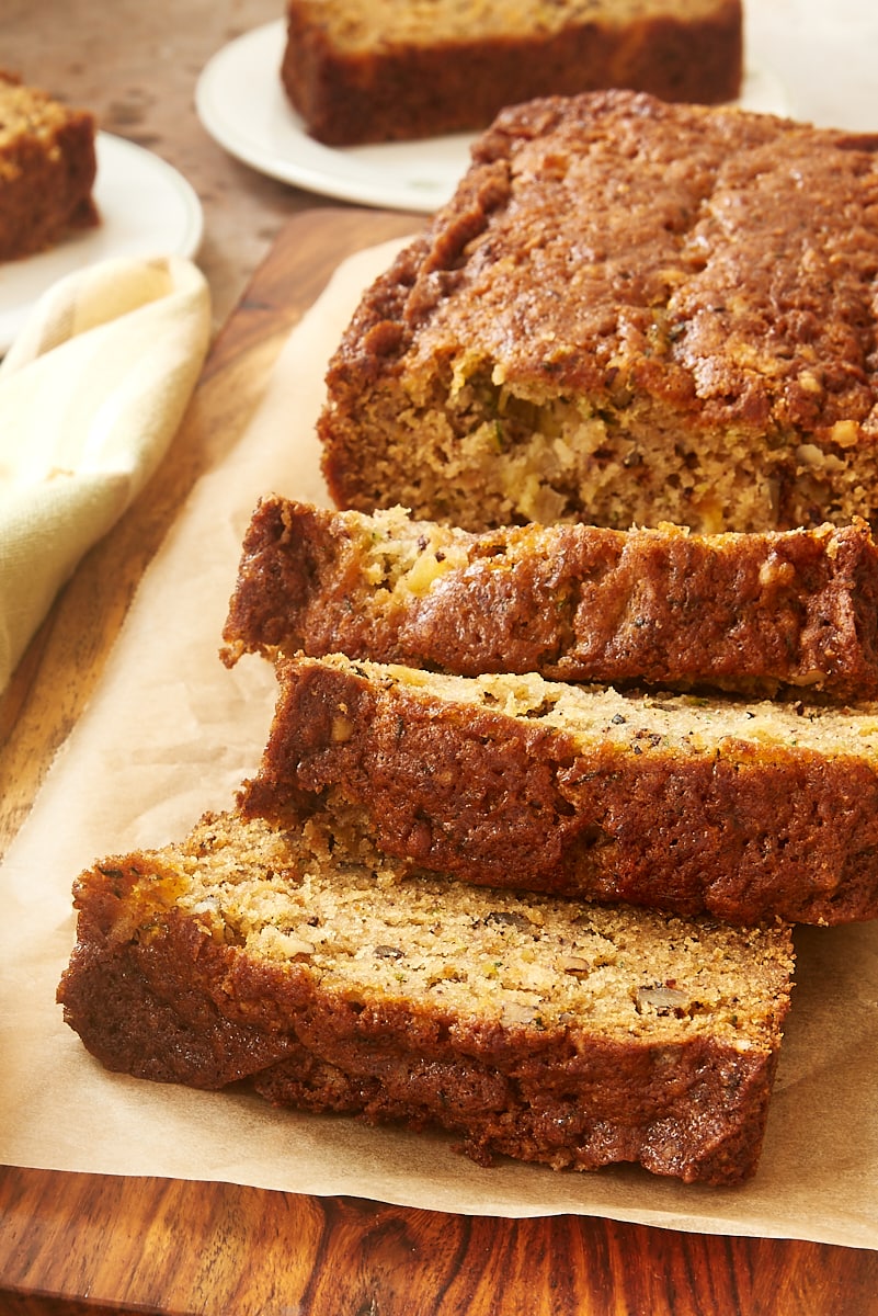 sliced Pineapple Zucchini Bread on a wooden cutting board with more slices in the background