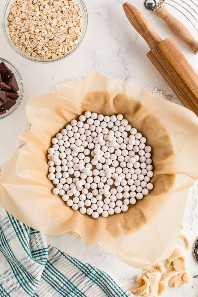 Parchment paper and pie weights in a pie crust.