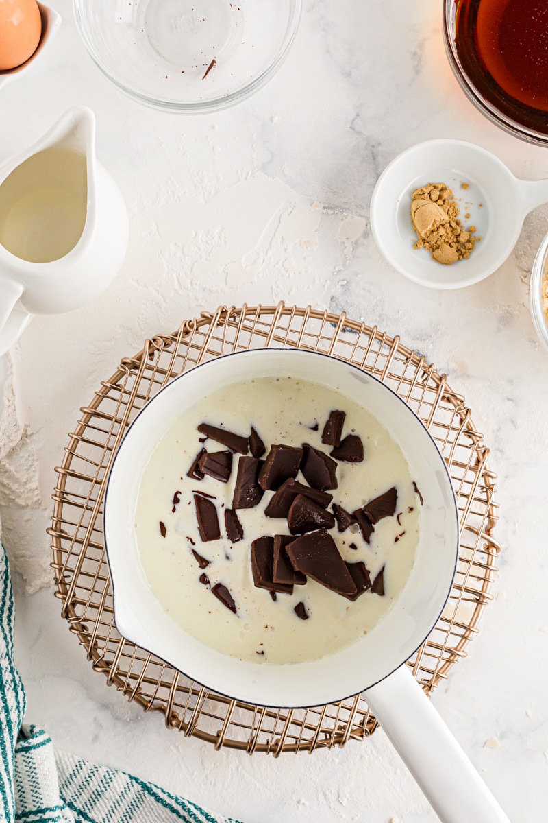 Chunks of dark chocolate in a pan full of cream.