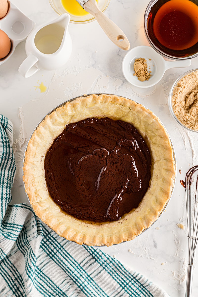 Ganache spread evenly over the bottom of a pie crust.