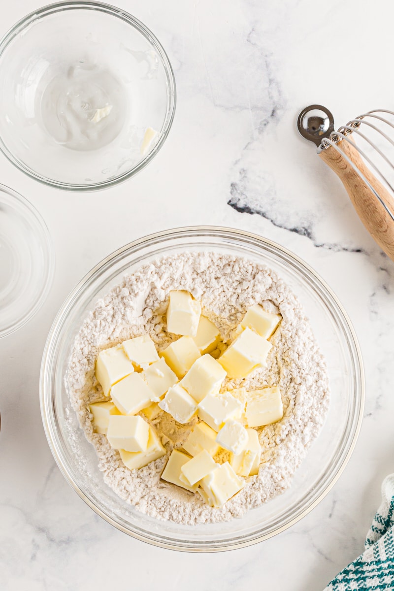 Cold cubes of diced butter on top of flour in a bowl.