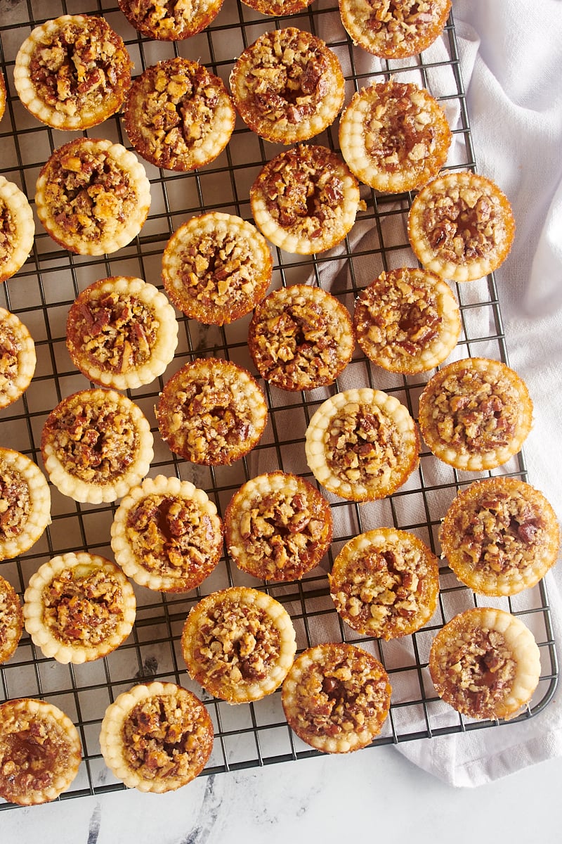 Mini Pecan Pies cooling on a wire rack on the counter.
