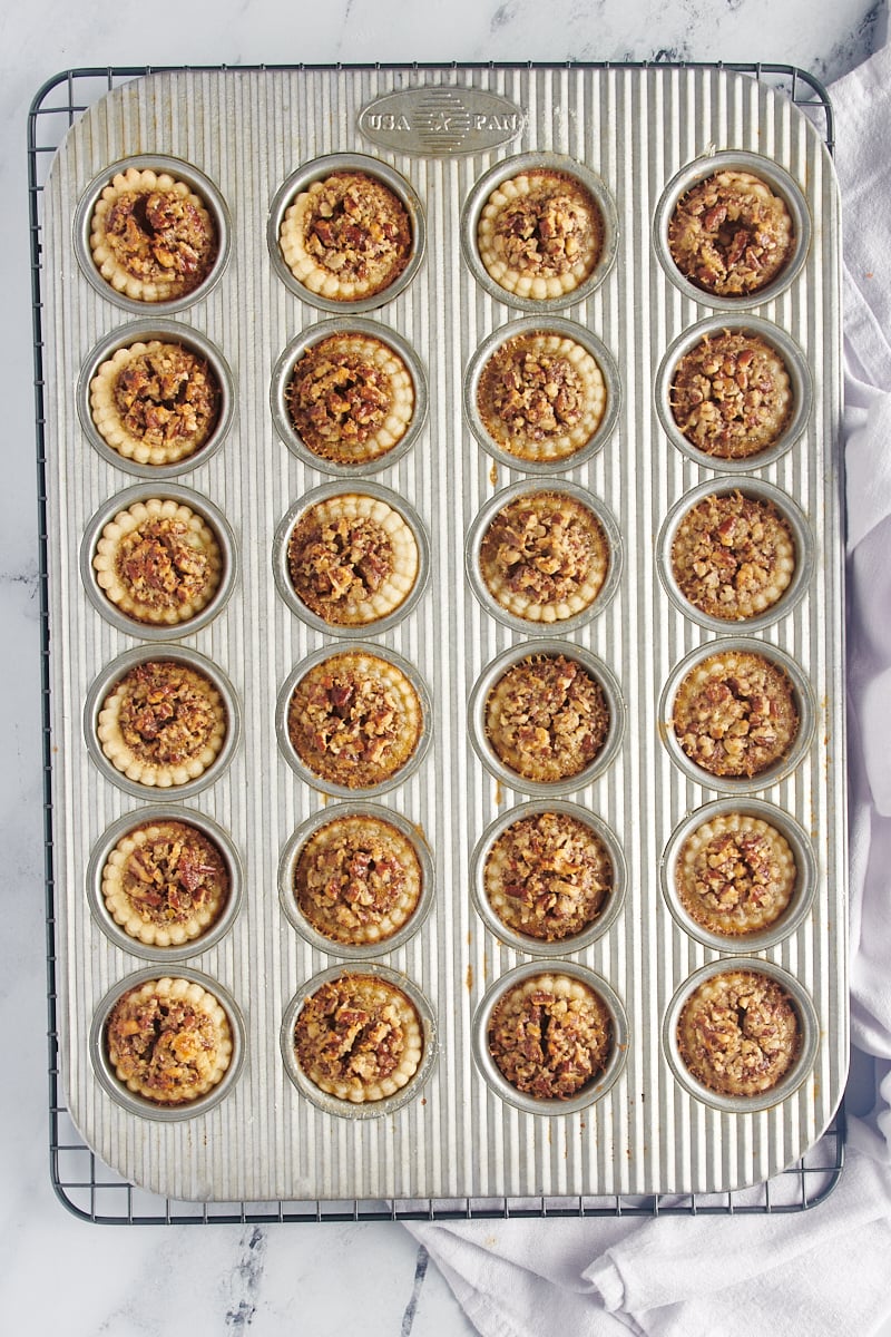 Mini Pecan Pies in a muffin tin fresh out of the oven.