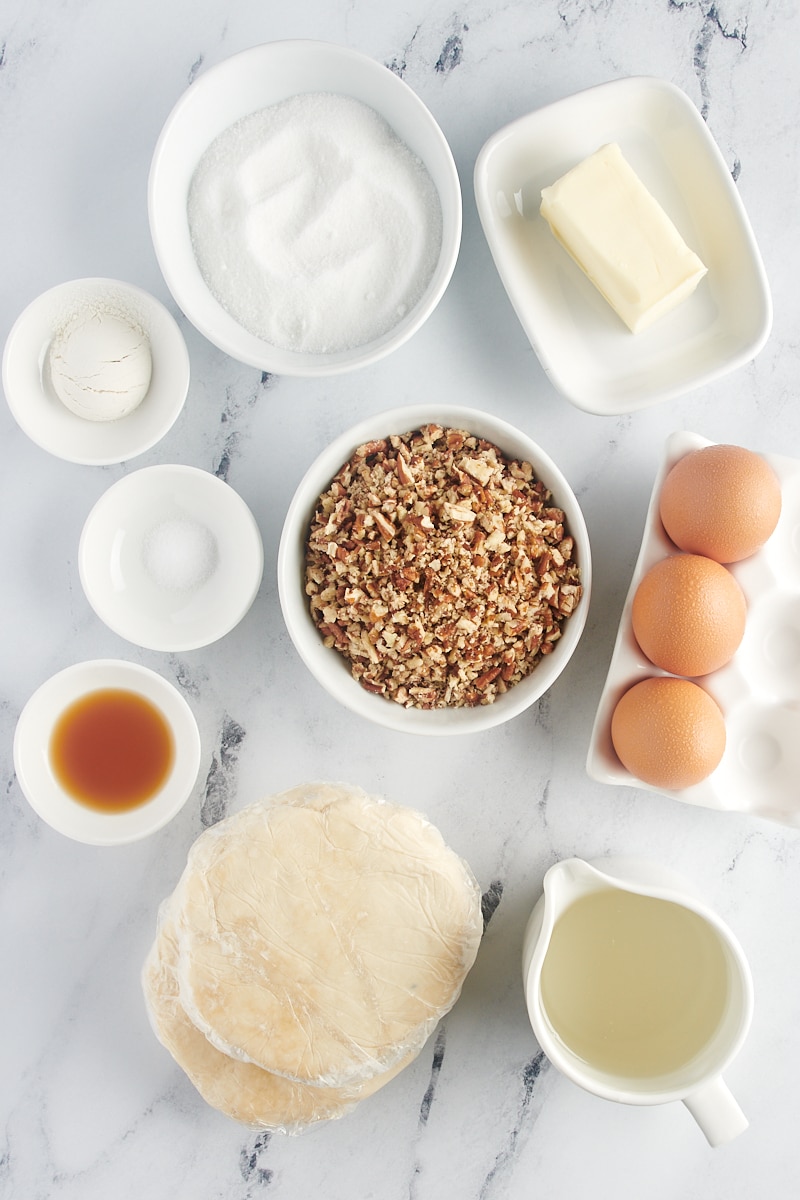 All the ingredients for Mini Pecan Pies set out in bowls on the counter.