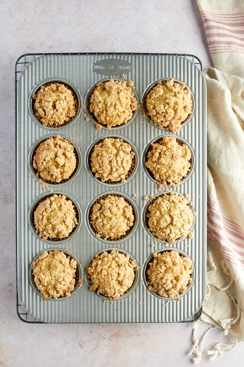 overhead view of freshly baked Apple Cinnamon Muffins in a muffin pan on a wire rack