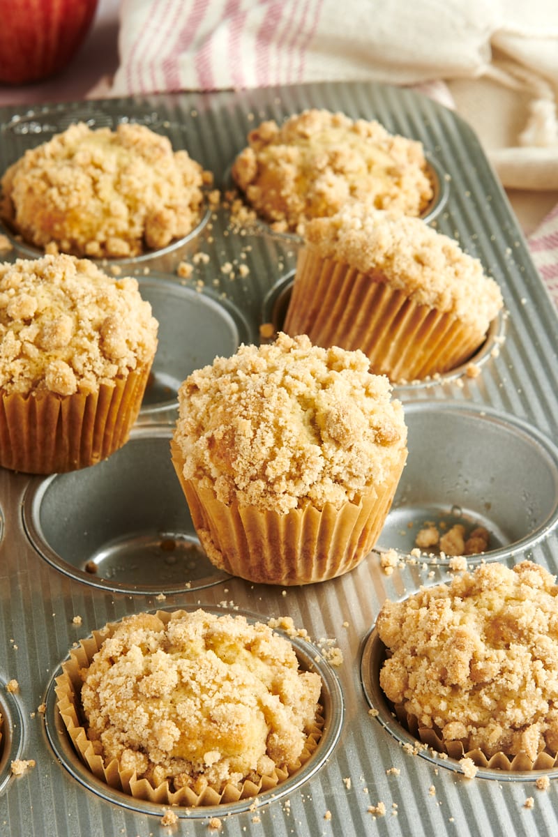 Apple Cinnamon Muffins scattered in and on a muffin pan