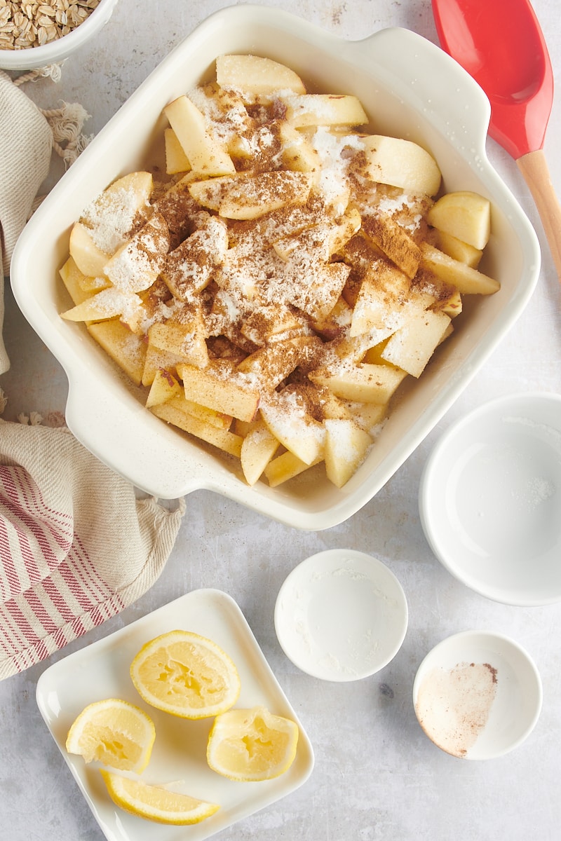 Cinnamon and sugar in a baking pan with apple slices.