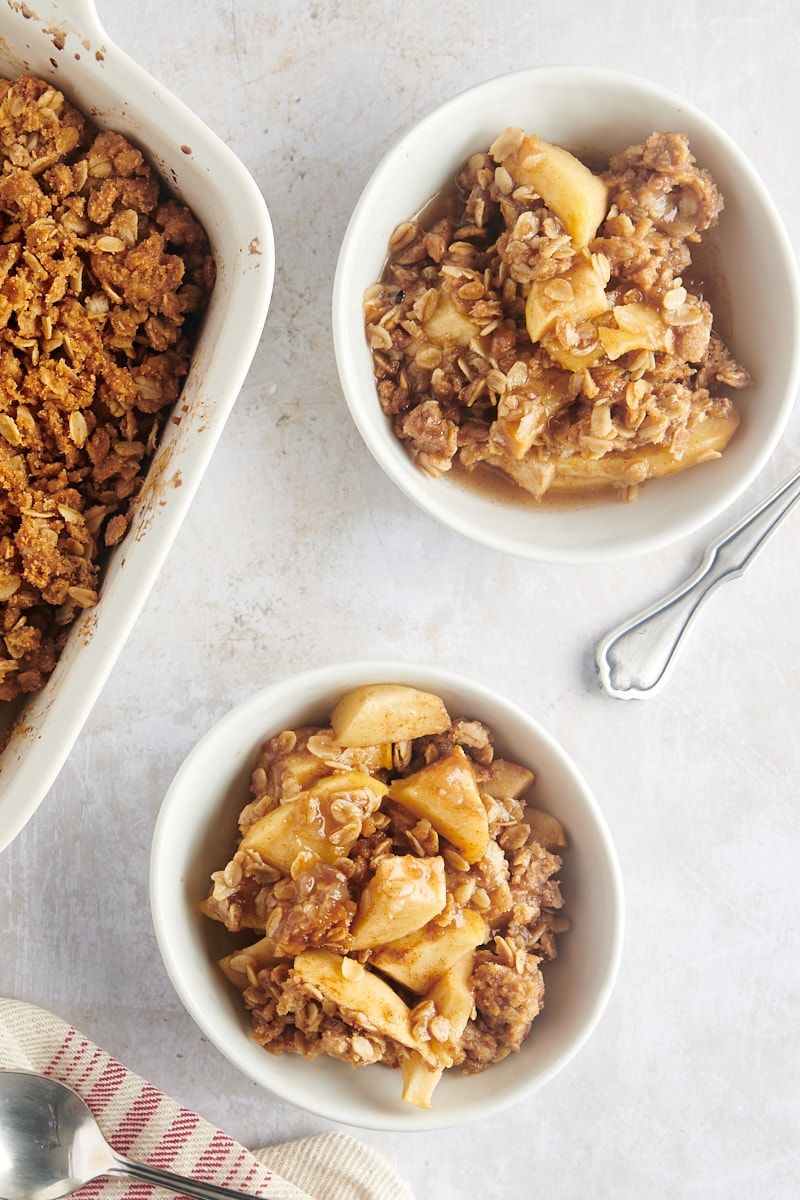 Two bowls of apple crisp side by side on the countertop.