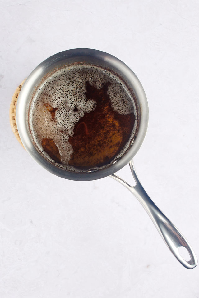 Browned butter bubbling in the bottom of a saucepan.