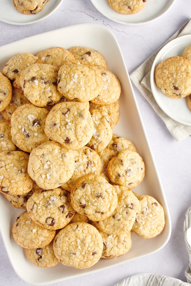 A platter of cookies on the table next to three plates of cookies.