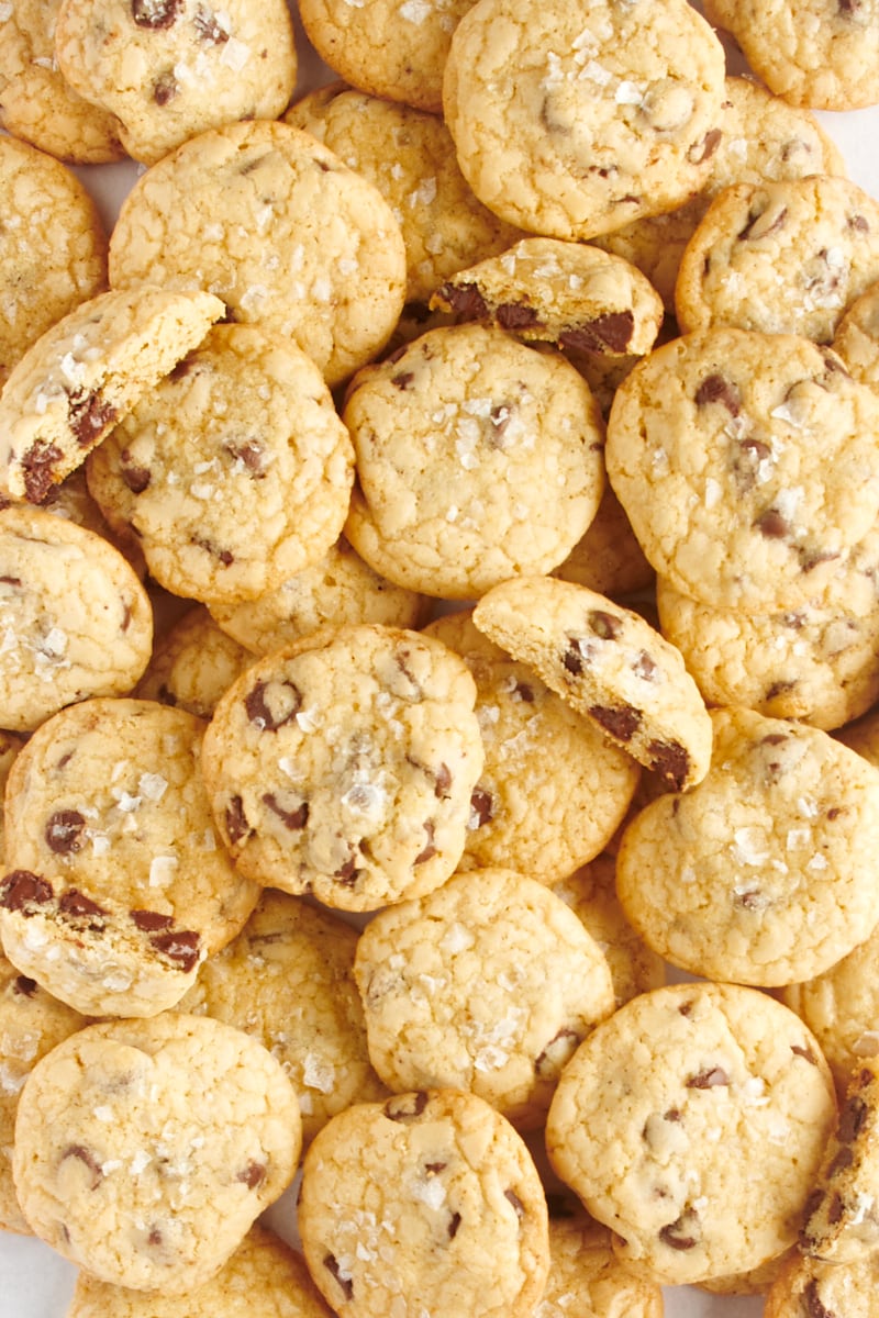 A big pile of salted chocolate chip cookies, some of which are cut in half.