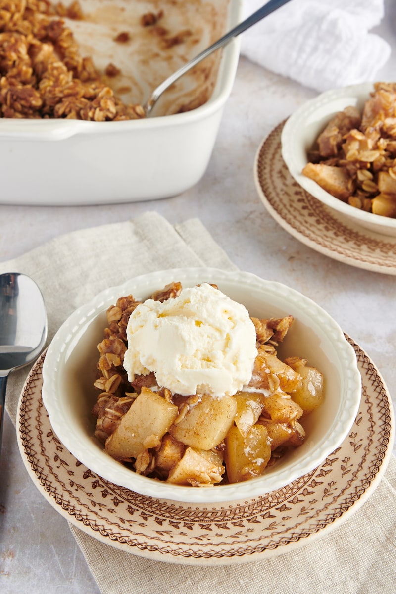 a serving of Brown Butter Pear Crisp topped with ice cream and served in a white bowl