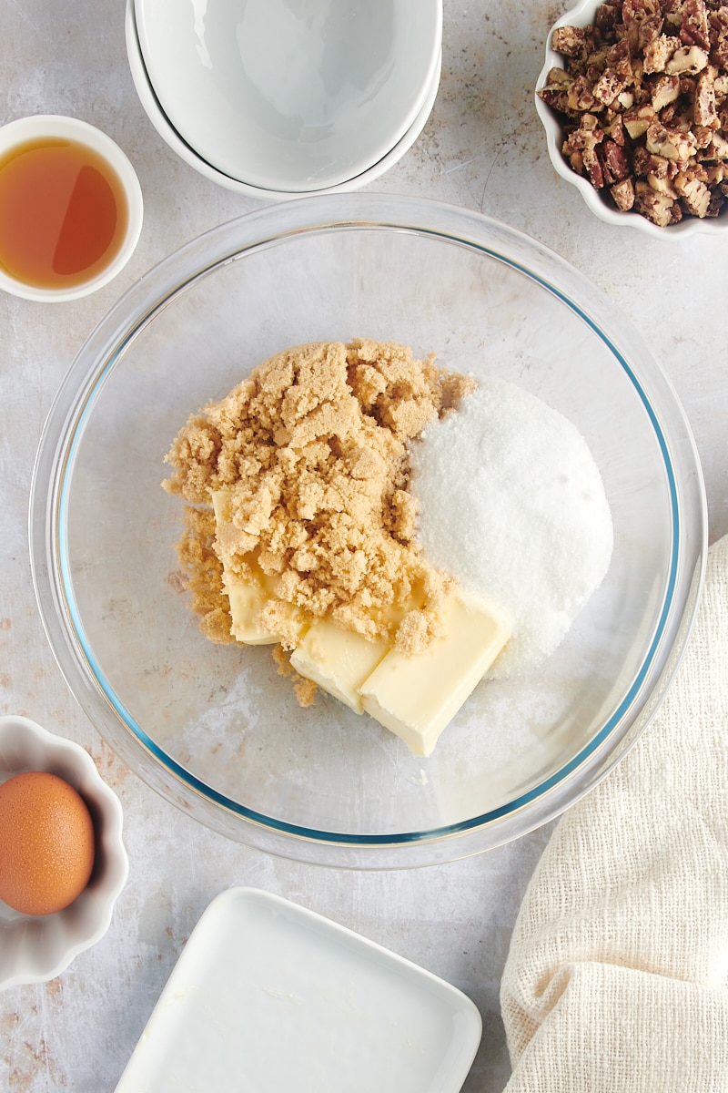 overhead view of butter, brown sugar, and granulated sugar in a glass mixing bowl