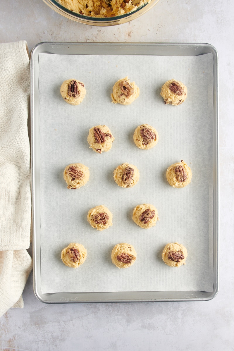 Вид сверху на шарики из теста Maple Pecan Cookie с половинками орехов пекан