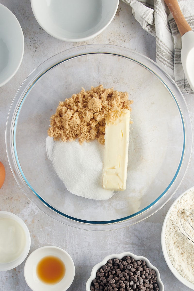 overhead view of butter, sugar, and brown sugar in a glass mixing bowl