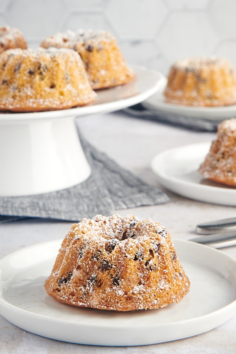 a Mini Chocolate Chip Bundt Cake on a white plate with more cakes in the background