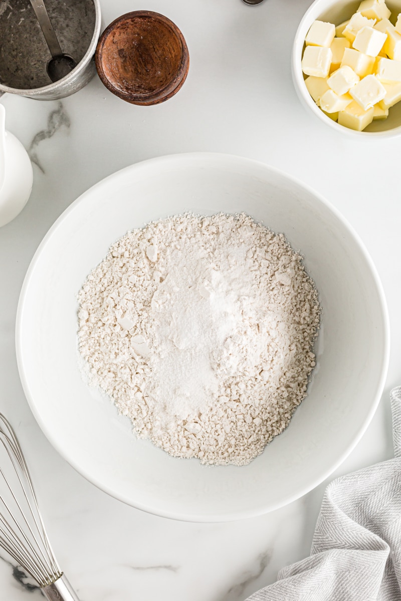 overhead view of flour, sugar, and salt mixed in a white mixing bowl